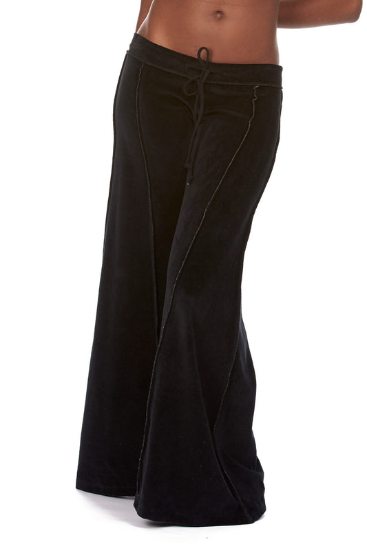 Black velvet flow pants with extra-wide flare and drawstring waist, styled on a model.