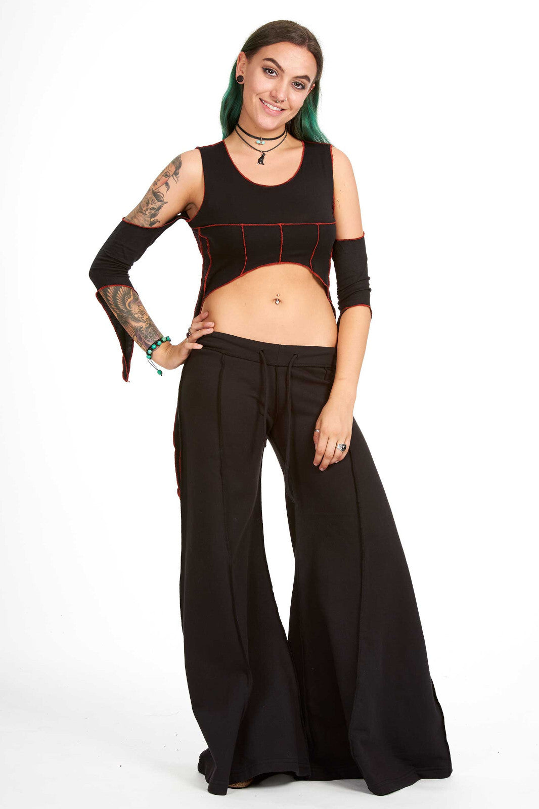 Black extra wide flare flow pants made of soft sweater fabric with a drawstring waist and extra long legs, paired with a cropped black tank top.