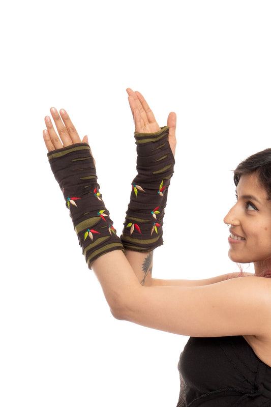 Dark Brown & Green Lily Leaf Armwarmers with colorful embroidered leaf details and striped banding, displayed on a model's raised arms against a white background.
