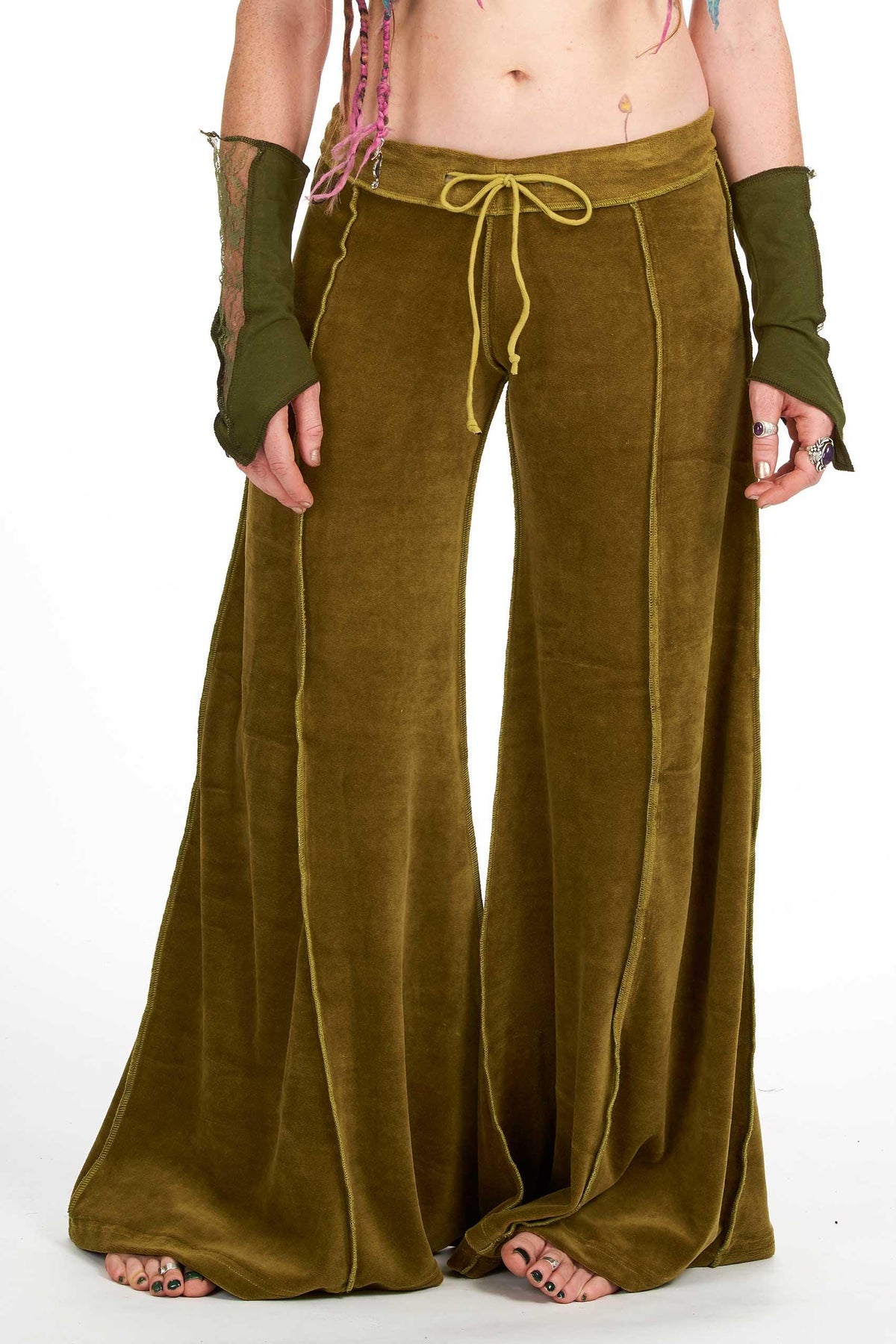 Green velvet flow pants with extra-wide flare, drawstring waist, and long legs, styled with coordinating arm warmers.